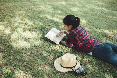 High angle view of boy holding sunglasses on field