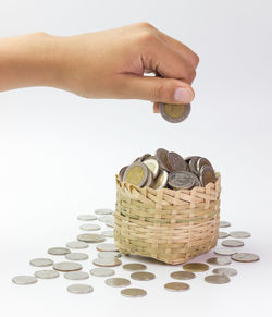 Cropped hand of person putting coins into basket