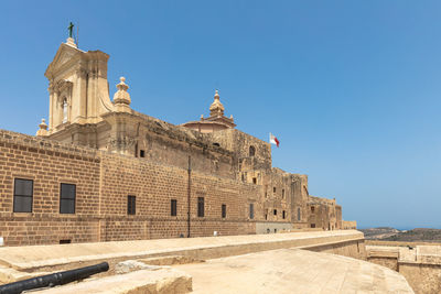 Low angle view of historical building against clear blue sky