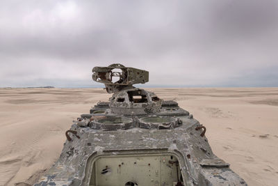 Army tank with bullet holes on the beach