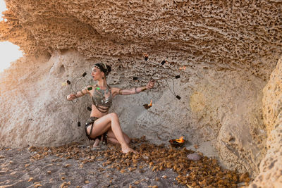 Full length of woman dancing against rock formation