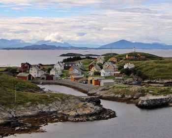 Houses by river against sky