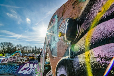 Low angle view of graffiti on bridge against sky