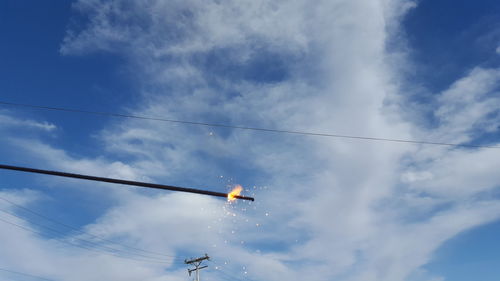 Low angle view of burning cable against cloudy sky