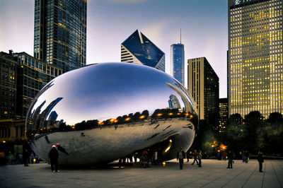 People in modern buildings against clear sky