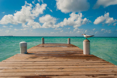 Wooden pier on sea against sky