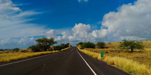 Road amidst landscape against cloudy sky 