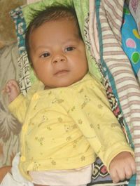 Portrait of cute baby girl lying on bed