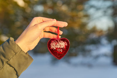 Midsection of woman holding red heart