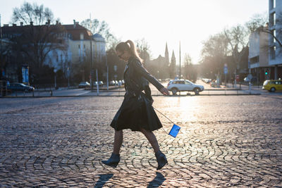 Full length of woman walking on street in city