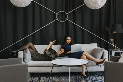 Female coworkers working on sofa