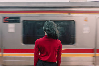 Rear view of man standing at railroad station