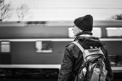 Rear view of man standing at railroad station platform