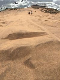 High angle view of people on sand dune at beach
