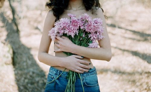 Midsection of woman holding flower