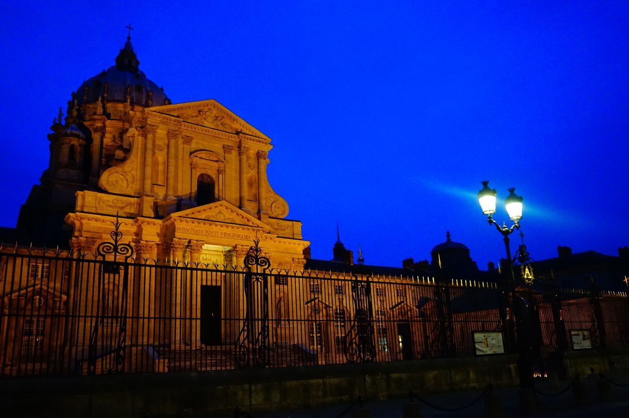 LOW ANGLE VIEW OF ILLUMINATED BUILDING AGAINST BLUE SKY