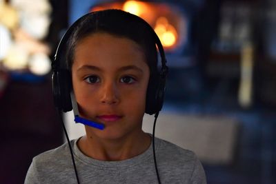 Close-up portrait of boy with headphones at home