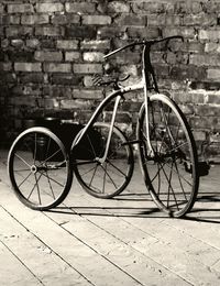 Bicycle parked against brick wall