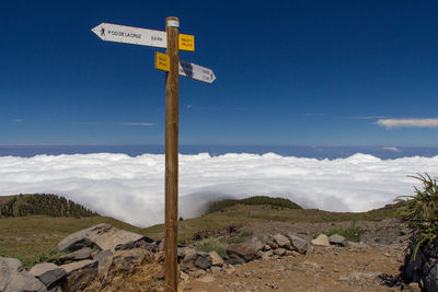 Road sign against sky