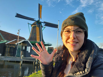 Portrait of smiling young woman against blue sky