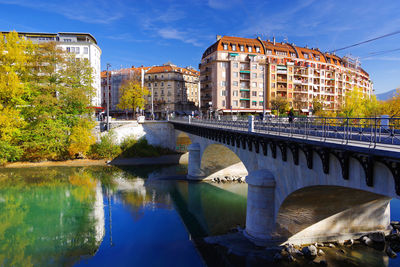 Bridge over river against buildings