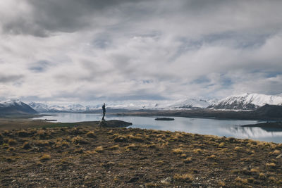 Young woman stands towards the southern alps in background new zealand