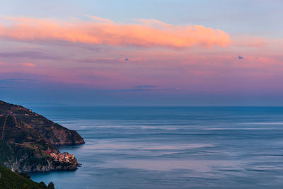 The fishing village of manarola in cinque terre, italy, at sunset with the mediterranean sea