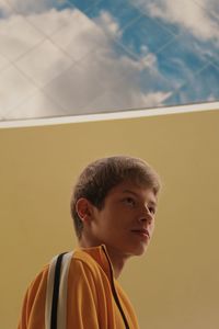 Thoughtful teenage boy by wall