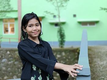 Portrait of young woman standing against sea