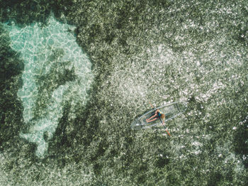 Aerial view of woman on inflatable boat in sea