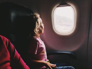 Rear view of woman sitting in airplane