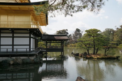 Houses by lake against sky