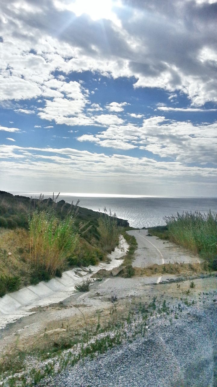 water, sky, tranquil scene, tranquility, sea, scenics, cloud - sky, beauty in nature, grass, horizon over water, nature, beach, cloud, shore, cloudy, plant, landscape, idyllic, day, sand