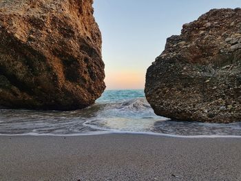 Rocks on beach against clear sky