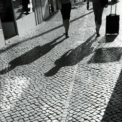 Low section of people walking on tiled floor