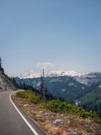 Road by mountains against clear sky