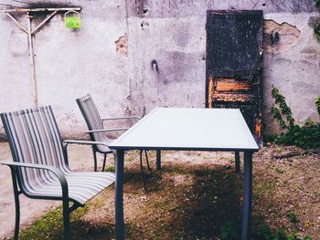 Empty chairs and table against plants