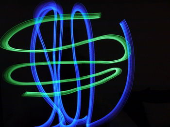 Close-up of illuminated lighting equipment against black background