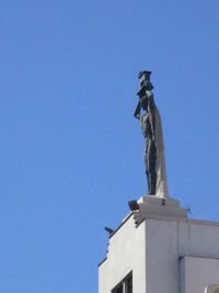 Low angle view of statue against clear blue sky