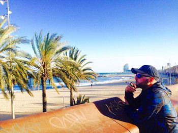 Man at beach against clear sky