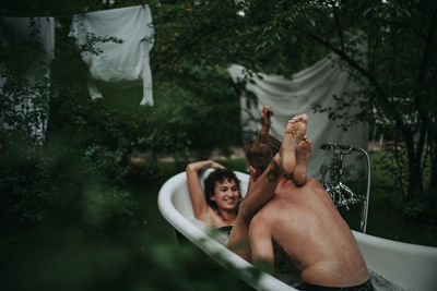 Rear view of people enjoying in water