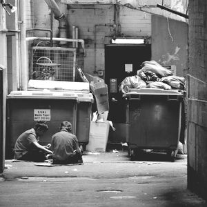 Rear view of man sitting in front of wall