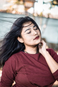 Young woman with eyes closed standing outdoors