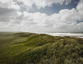 High angle view of coastline against cloudy sky