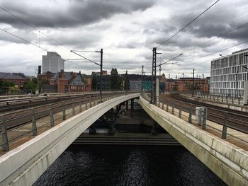 Railroad tracks in city against sky