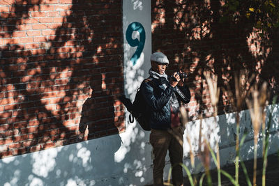 Full length of man standing against wall