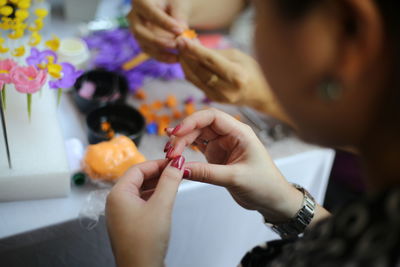 Cropped image of woman making crafts at table