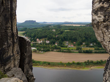 Scenic view of landscape by river against sky