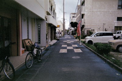 Bicycles on city street against sky