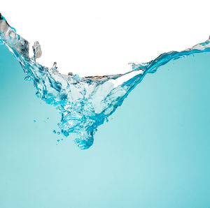 Close-up of water splashing against blue background